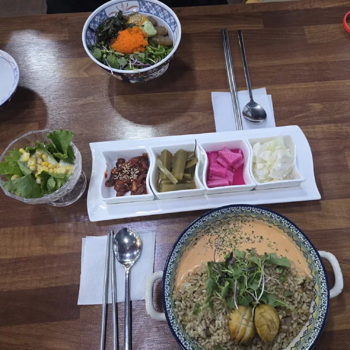 어느멋진날 테이블에 반찬 네 가지와 달걀장덮밥, 명란크림 볶음밥이 함께 놓인 모습