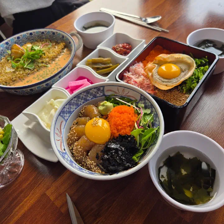 어느멋진날 테이블 위에 참치 덮밥과 명란젓갈 리조또, 소라 계란후라이 덮밥, 반찬들이 함께 차려져 있다