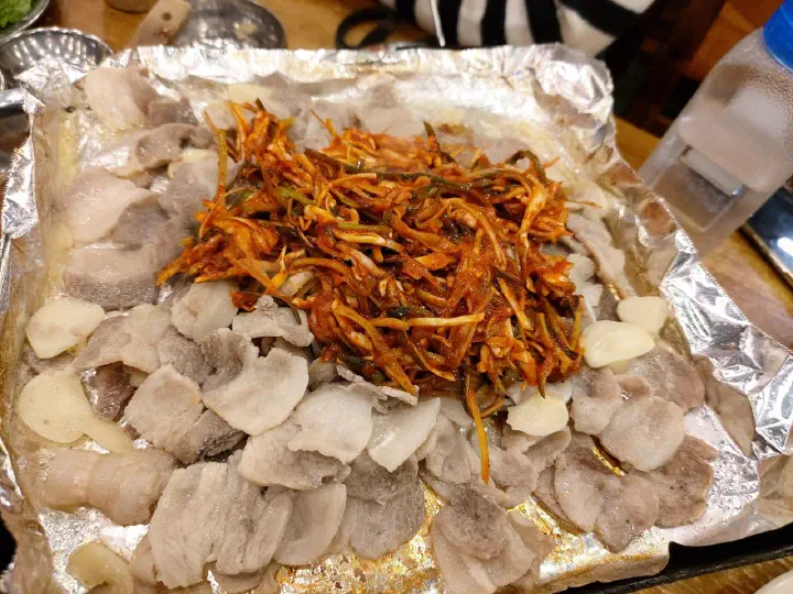 청주 봉용불고기 익힌 삼겹살 위에 새콤한 파절이를 올리는 모습