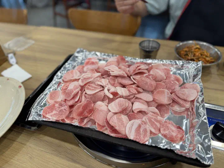 청주 봉용불고기 호일 불판 위에 올린 동그랗게 말린 냉동 대패삼겹살