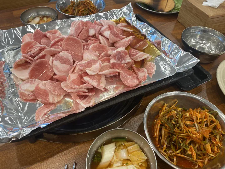 청주 봉용불고기 본점 불판에 올린 대패삼겹살과 파절이 반찬 상차림