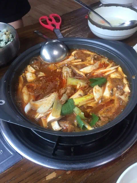 무쇠 냄비에서 빨간 양념 국물이 끓고 있는 두꺼비식당 매운 등갈비찜