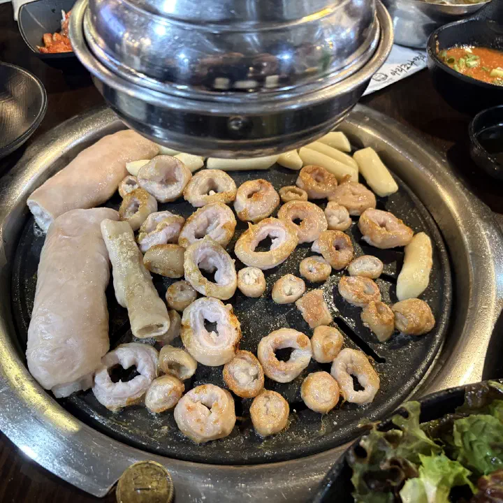 아리조나막창 불판 가득 동그랗게 썬 생막창과 떡