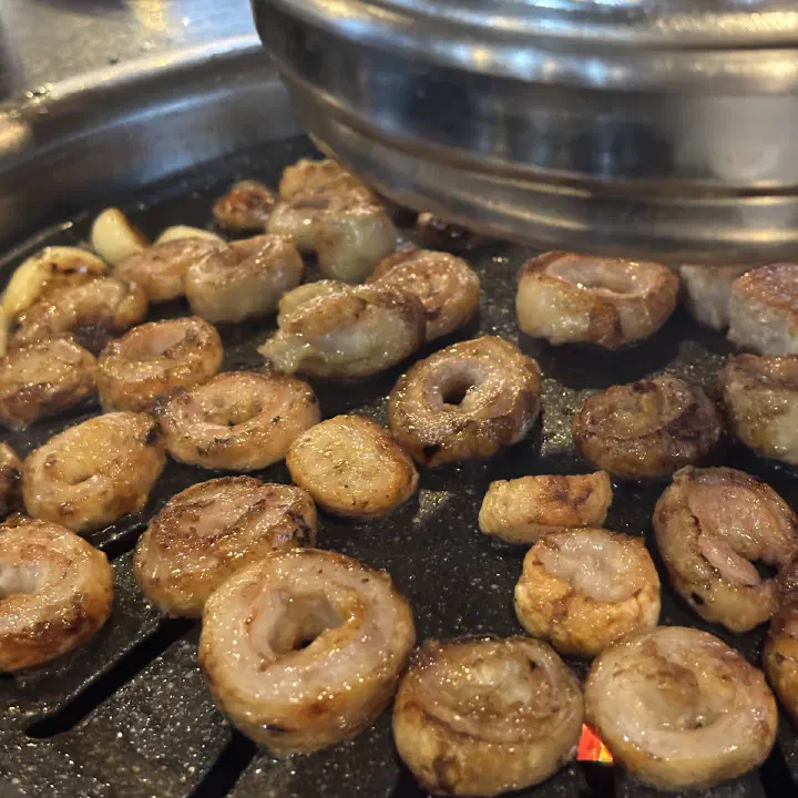 아리조나막창 생막창, 기름이 번들거리는 노릇한 막창 조각과 통마늘