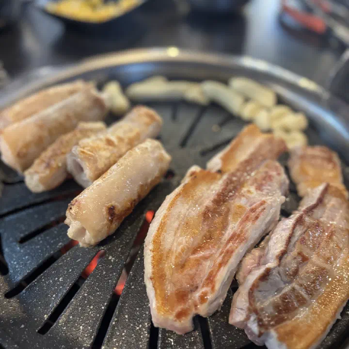 아리조나막창 숯불 불판 위 통통한 생막창과 두툼한 생삼겹살
