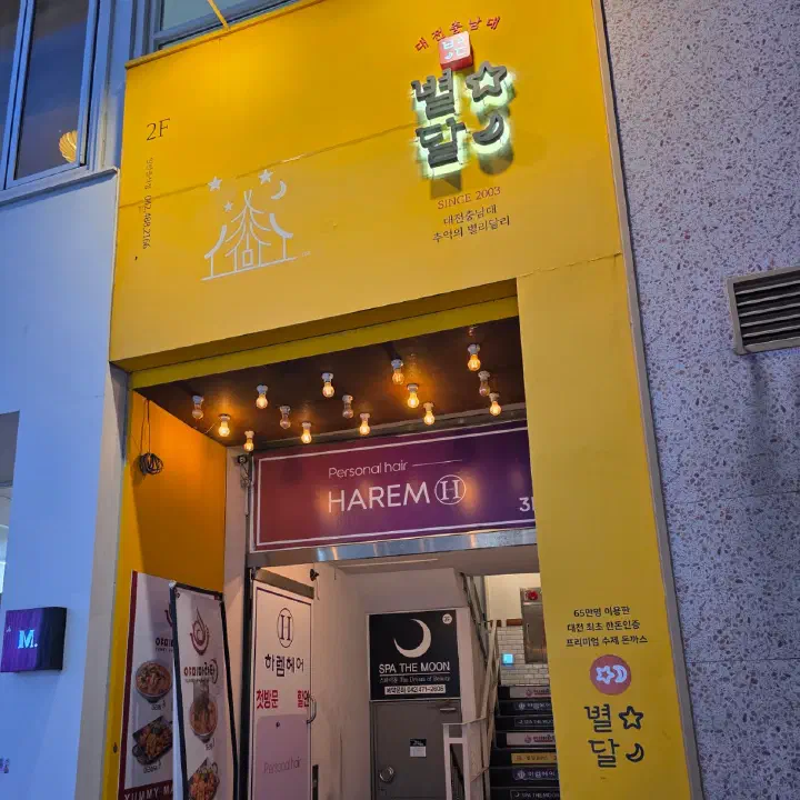 별달돈까스 노란색 건물 입구, 별달 간판과 2층 계단 통로
