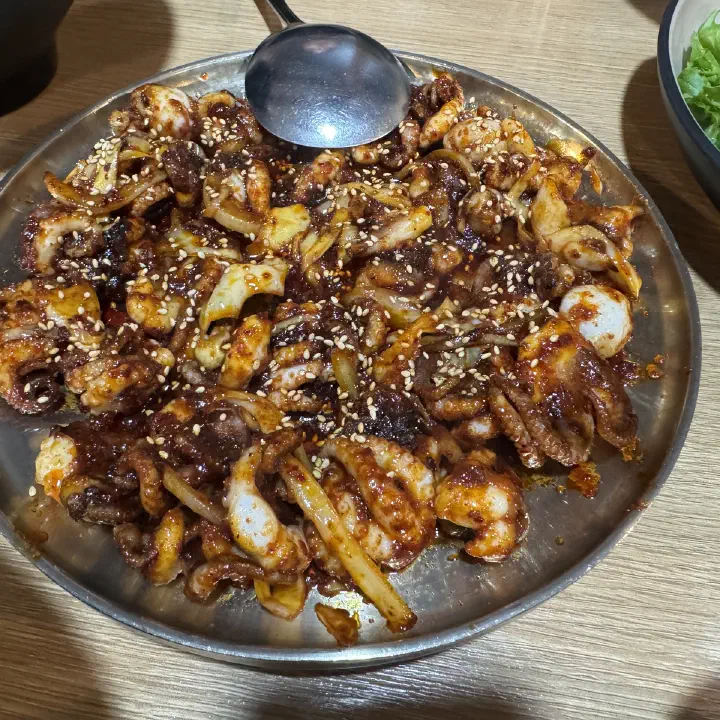 손의손 본점에서 나온 매콤한 양념 주꾸미볶음이 스테인리스 접시에 수북이 담긴 모습