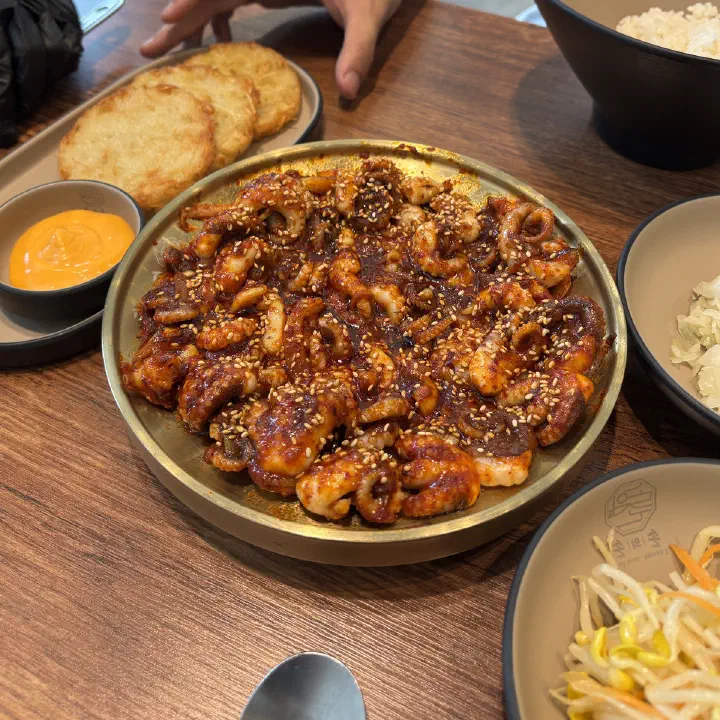 손의손 본점에서 양념 낙지볶음이 금색 접시에 담겨 나온 테이블 모습