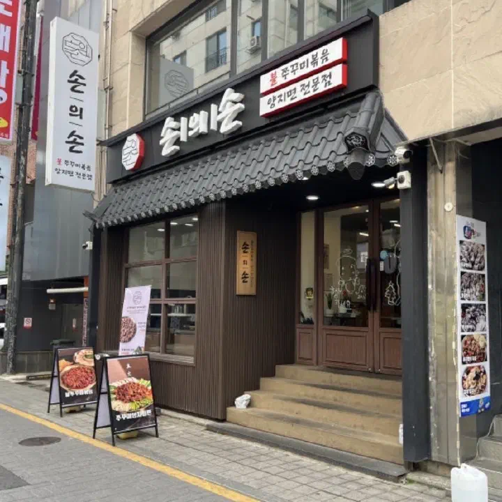 검은 기와 처마와 ‘손의손’ 간판이 달린 한식 음식점 정면 출입구 사진