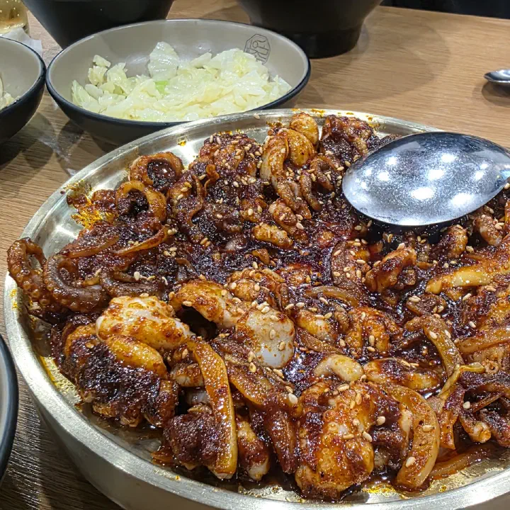 손의손 본점에서 주문한 매콤한 양념 낙지와 새우 볶음이 큰 철판에 담겨 나온 모습