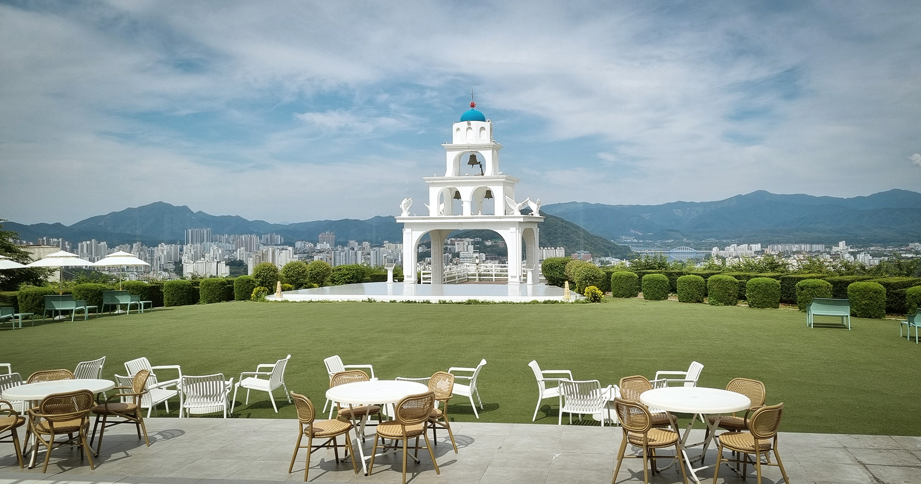 산토리니 테라스에서 본 잔디 마당의 파란 돔 종탑과 춘천 시내 전망