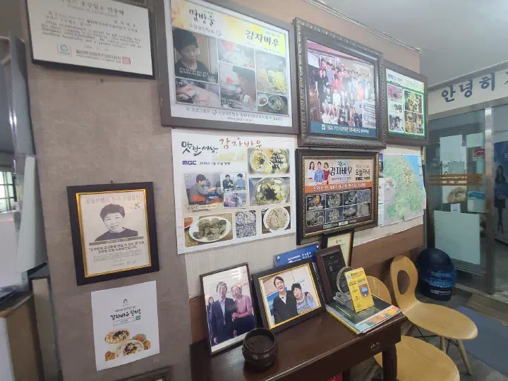 강릉 감자바우 매장 벽에 걸린 방송 출연 액자와 사진들