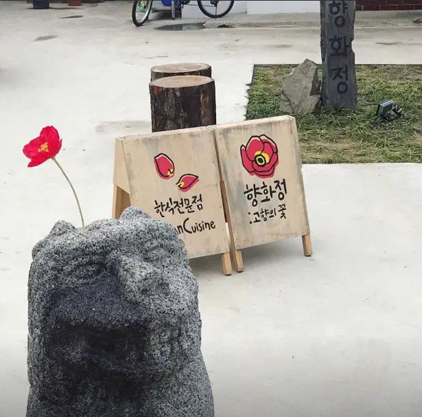 향화정 입구에 놓인 한식전문점 나무 간판과 돌사자상