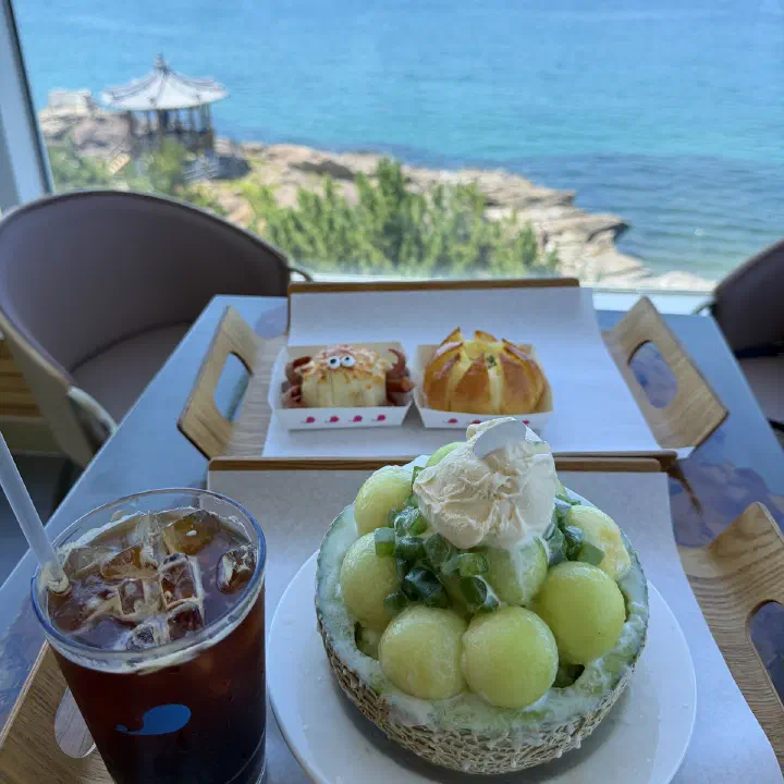 러블랑 창가 테이블의 멜론 빙수와 꽃게 모양 빵, 통창 너머 동해와 정자