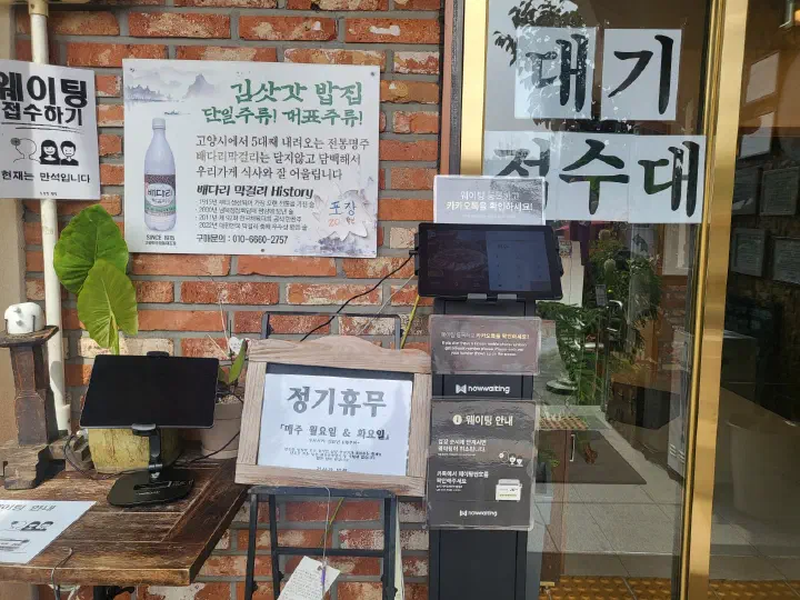 김삿갓밥집 입구에 놓인 웨이팅 접수 기기와 정기휴무 안내판