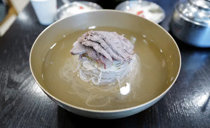 윤밀원 평양냉면 맑은 육수와 메밀면 위에 올린 고명 고기