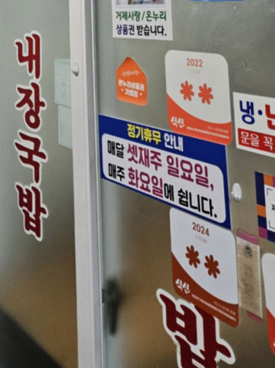충남식당 출입문에 붙은 매주 화요일·매달 셋째 주 일요일 정기휴무 안내와 식신 스티커