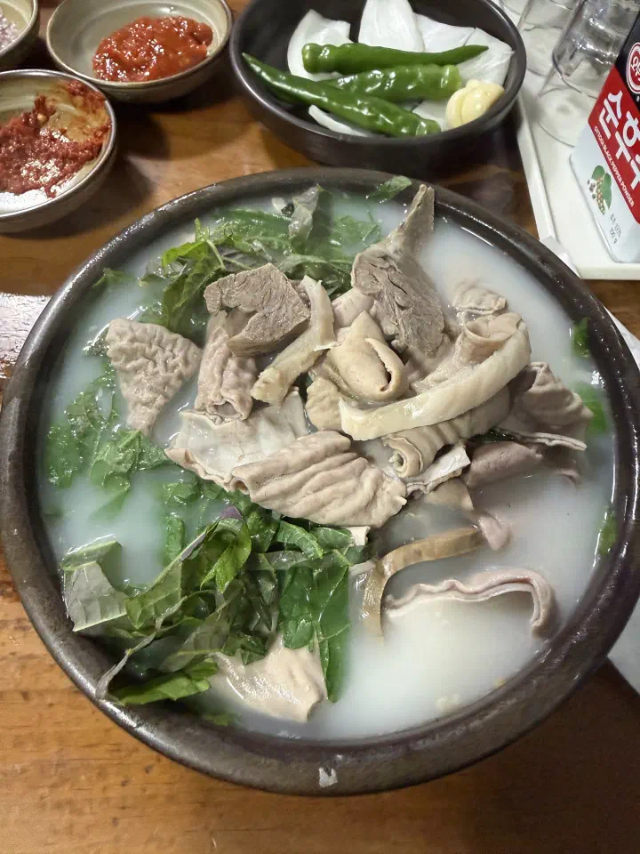 뽀얀 국물 위에 깻잎채를 수북이 올린 충남식당 내장국밥 클로즈업