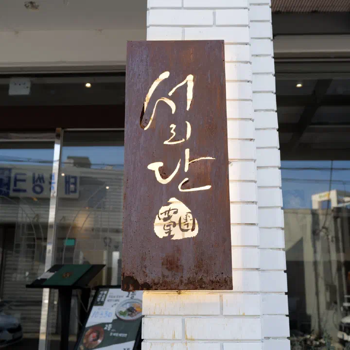 서리단 외관, 흰 벽돌 기둥의 녹슨 철판 간판과 바깥 메뉴판