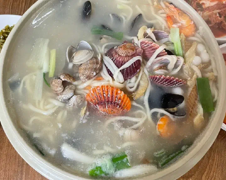 가리비와 홍합, 새우, 대파가 가득 올라간 영종도 해물칼국수를 위에서 내려다본 모습