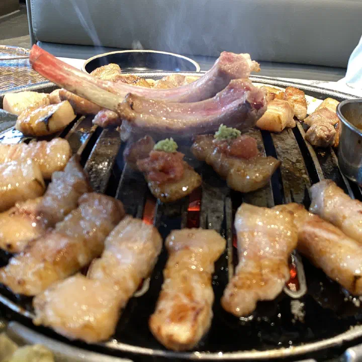 숙성도 중문점 불판 위에서 양갈비와 삼겹살 고기가 함께 구워지는 모습