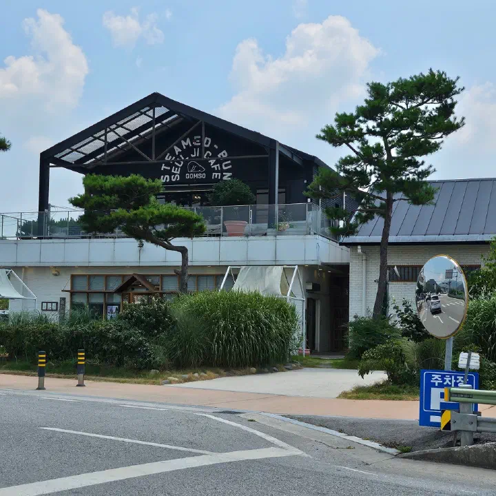 슬지제빵소 외관, 2층 검은 박공지붕 간판과 하얀 벽돌 건물