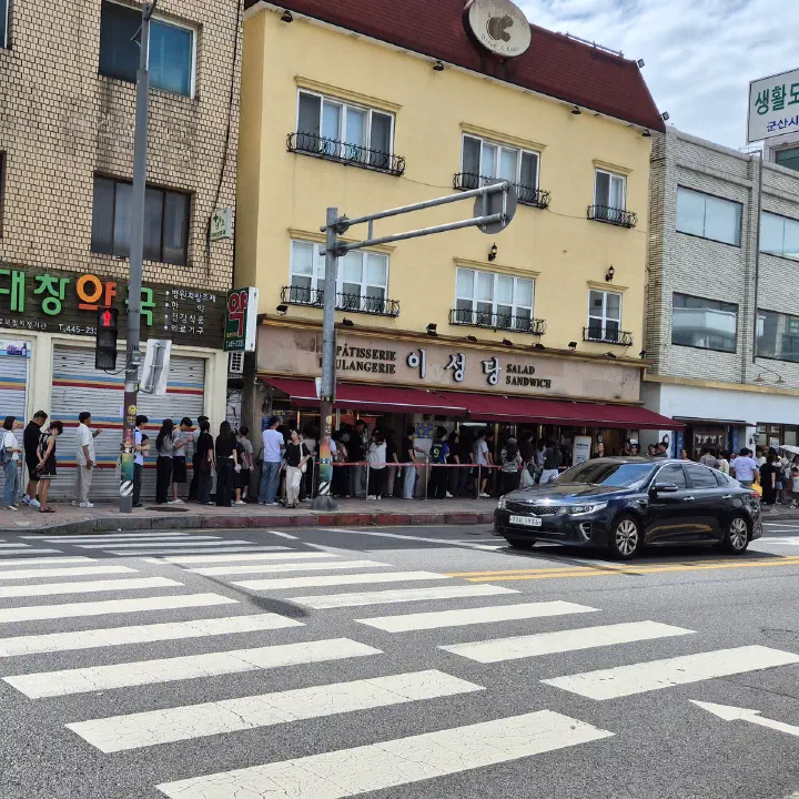 군산 이성당 제과점 건물 외관과 입구에 길게 줄 서 있는 사람들의 모습