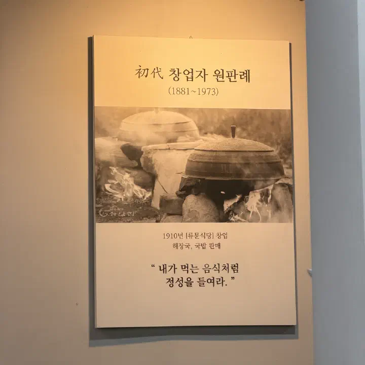 나주곰탕 하얀집 벽에 걸린 초대 창업자 원판례(1881~1973) 소개 액자, 가마솥에 불을 지펴 끓이는 옛 사진이 담겨 있다