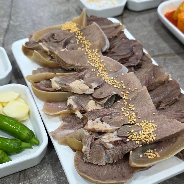 나주곰탕 하얀집에서 나온 편육 접시. 얇게 썬 소고기 수육 위에 참깨가 뿌려져 있다.