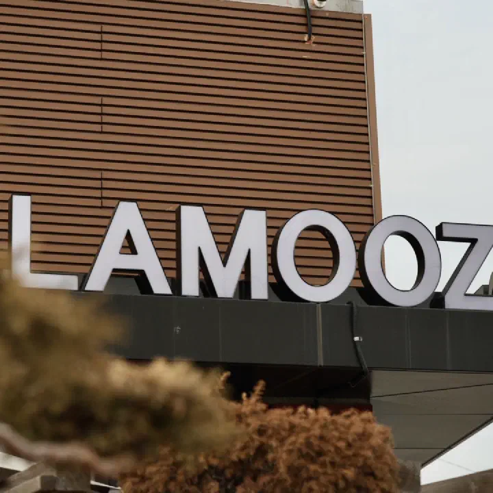 라무즈 외관, 목재 루버 벽 위 흰색 LAMOOZ 입체 간판