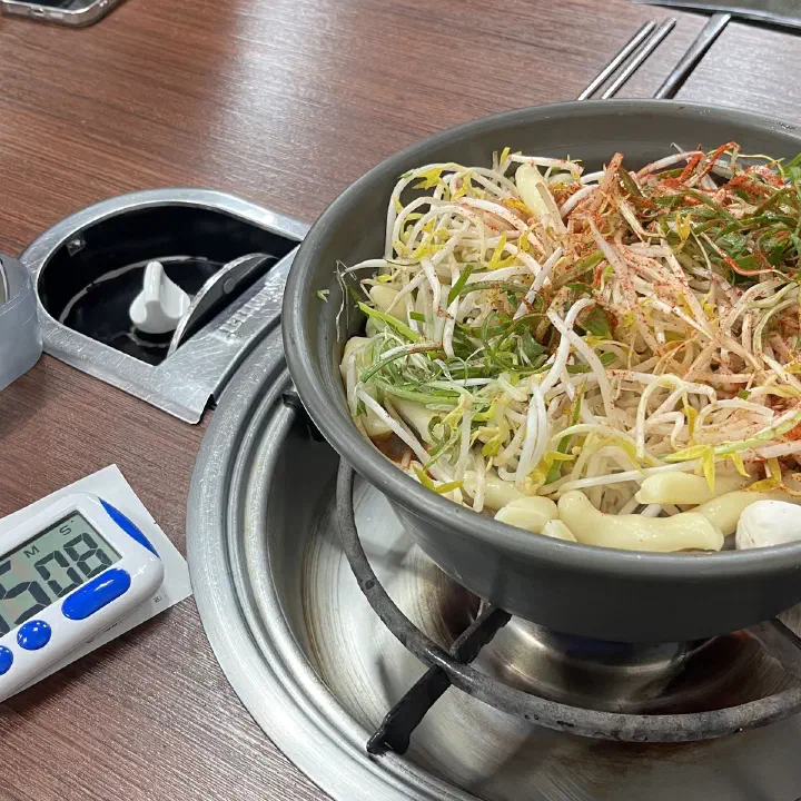 감동식당 노원본점에서 숙주와 미나리, 쪽파가 수북이 올라간 전골 냄비가 휴대용 가스버너 위에서 끓고 있다