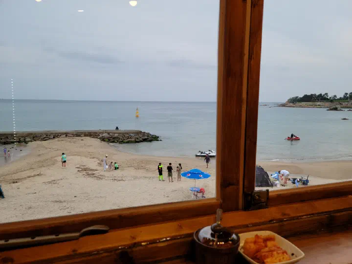 나사리식당 2층 창문 너머로 보이는 나사해수욕장 여름 해변 풍경