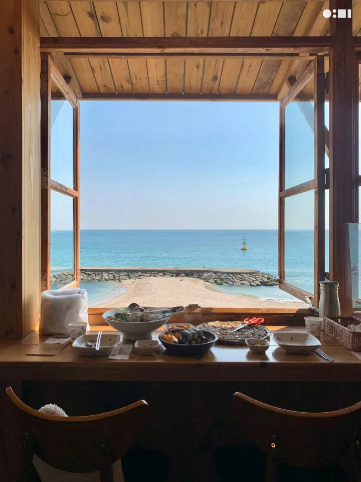 나사리식당 2인 창가 바 좌석에 차려진 칼국수 한상과 정면으로 보이는 바다